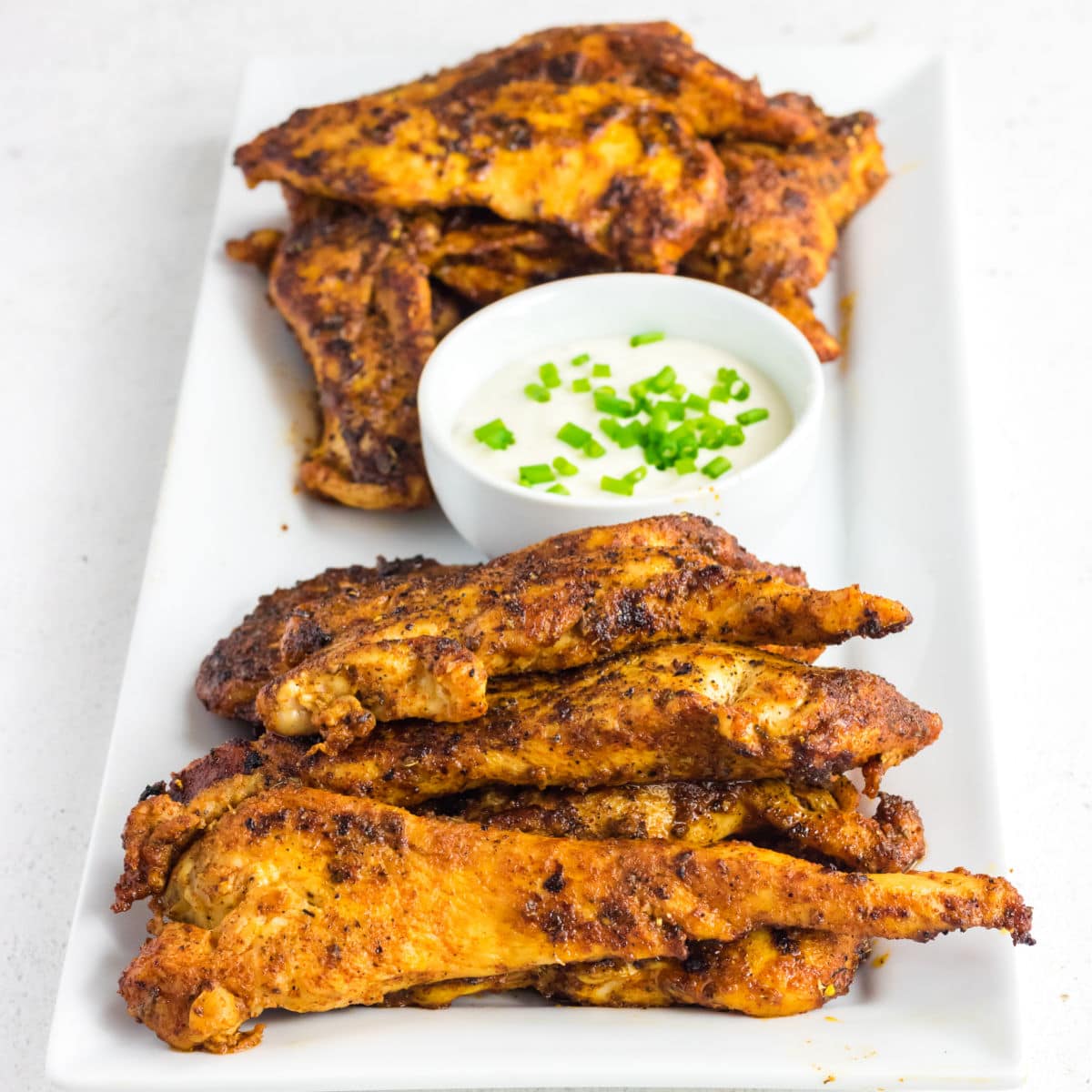 Closeup of chicken tenders on a serving platter.