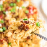 Closeup of a serving of pasta being removed from the dish with a text overlay for Pintrest.