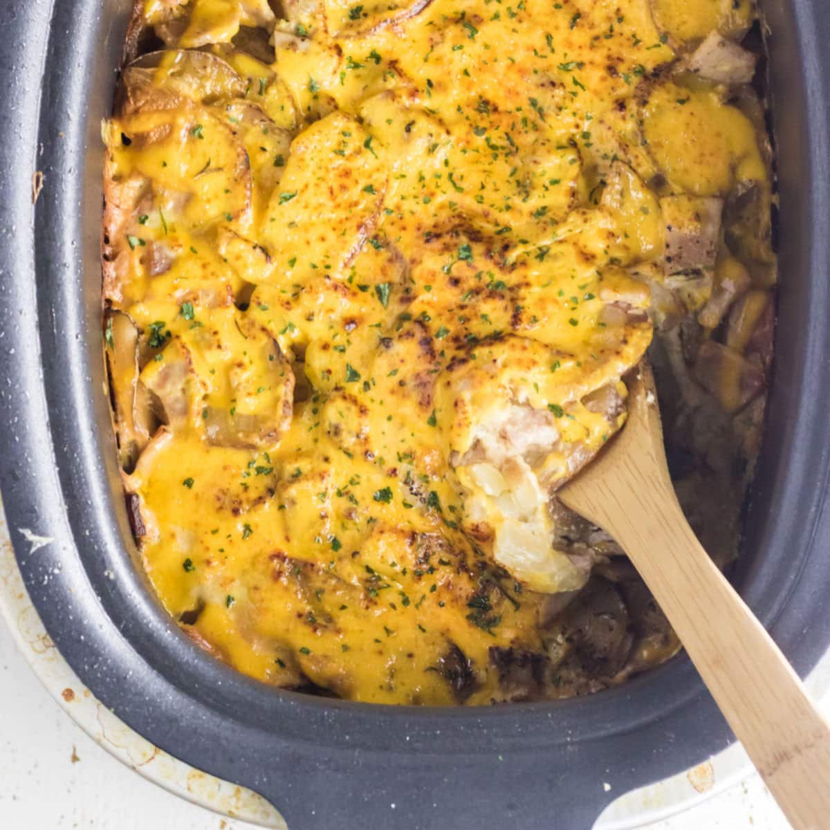 Finished scalloped potatoes in a slow cooker.