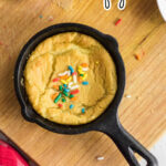 Overhead view of a cookie in a skillet with title text overlay for Pinterest.