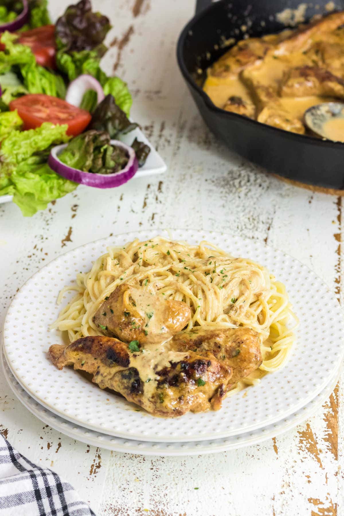 A plate with chicken and pasta on it.