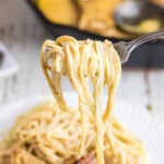 Pasta being twirled around a fork with a title text overlay for Pinterest.