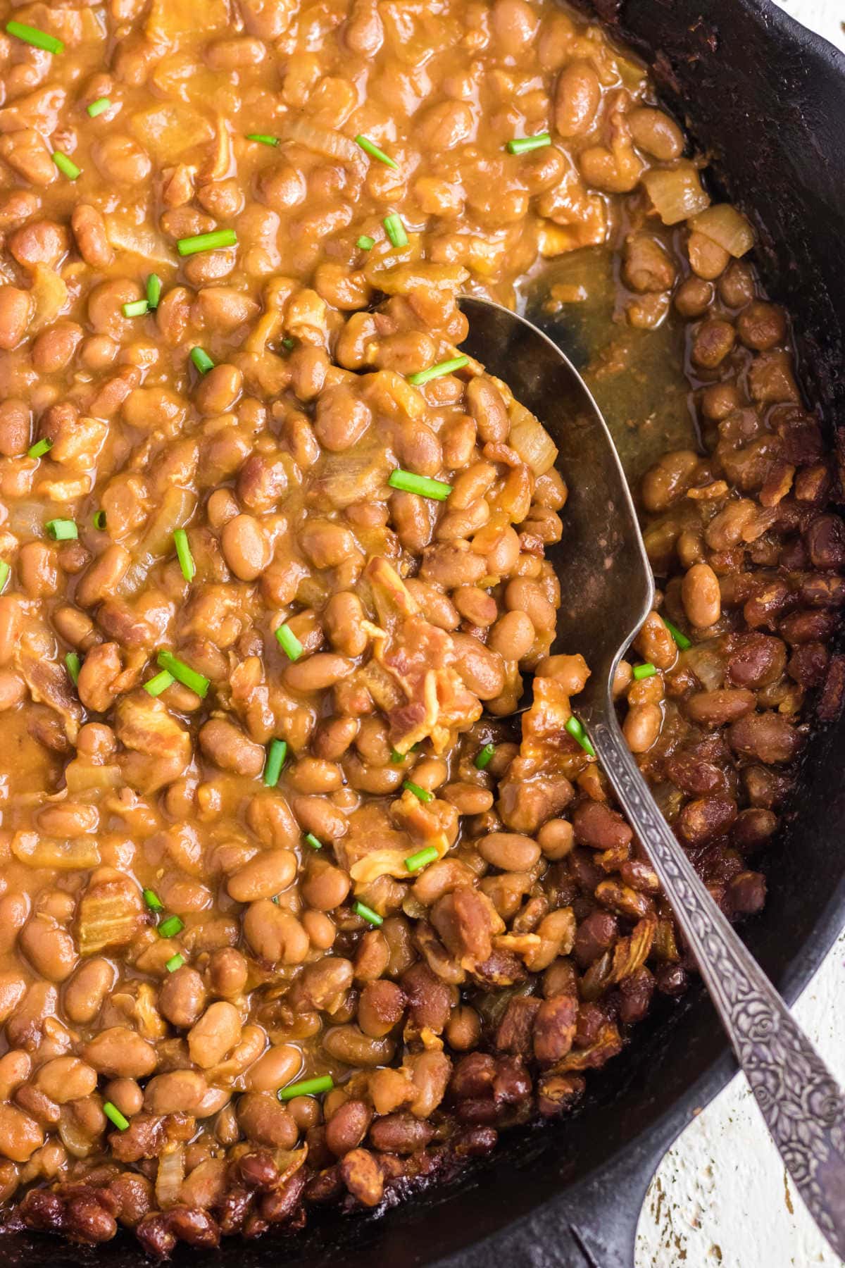 Closeup of finished baked beans showing sauce and texture.