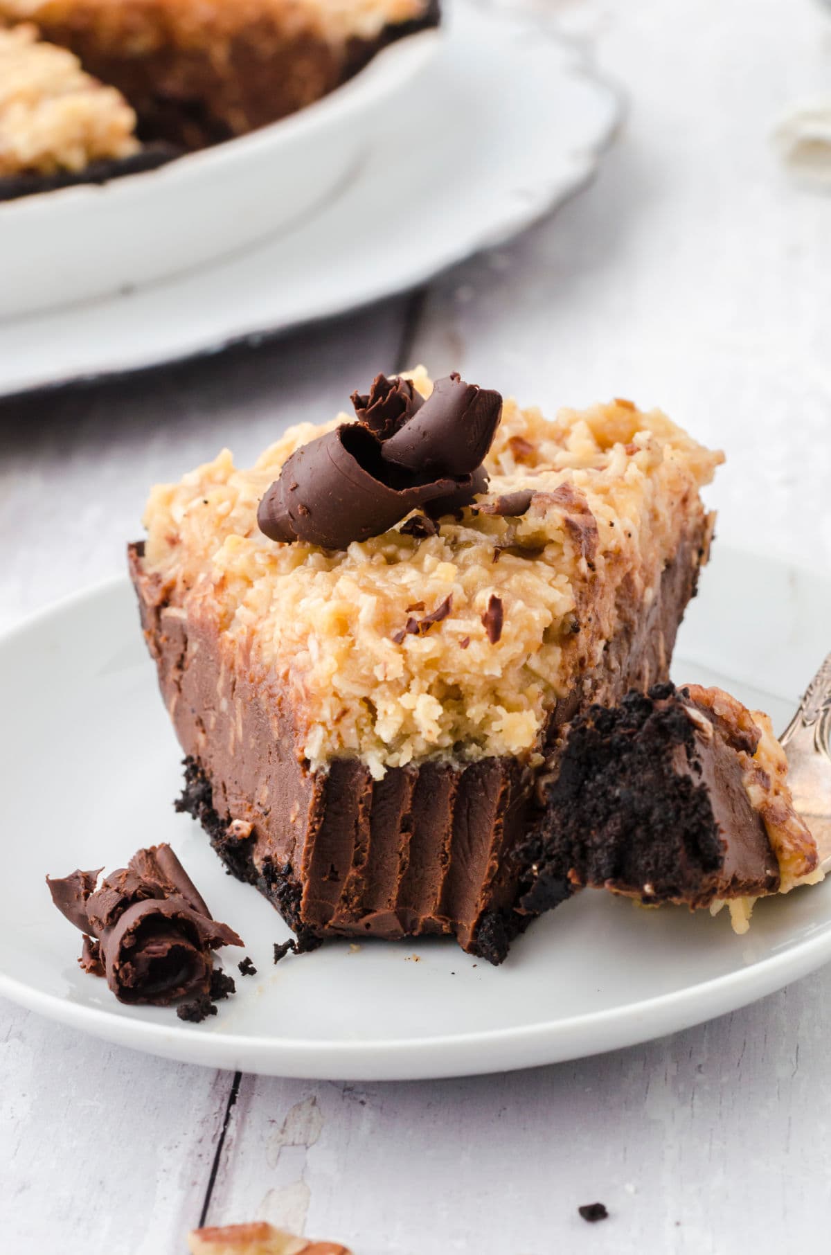 A slice of German chocolate pie with a bite removed.