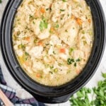 Closeup of a slow cooker filled with chicken and dumplings for feature image.