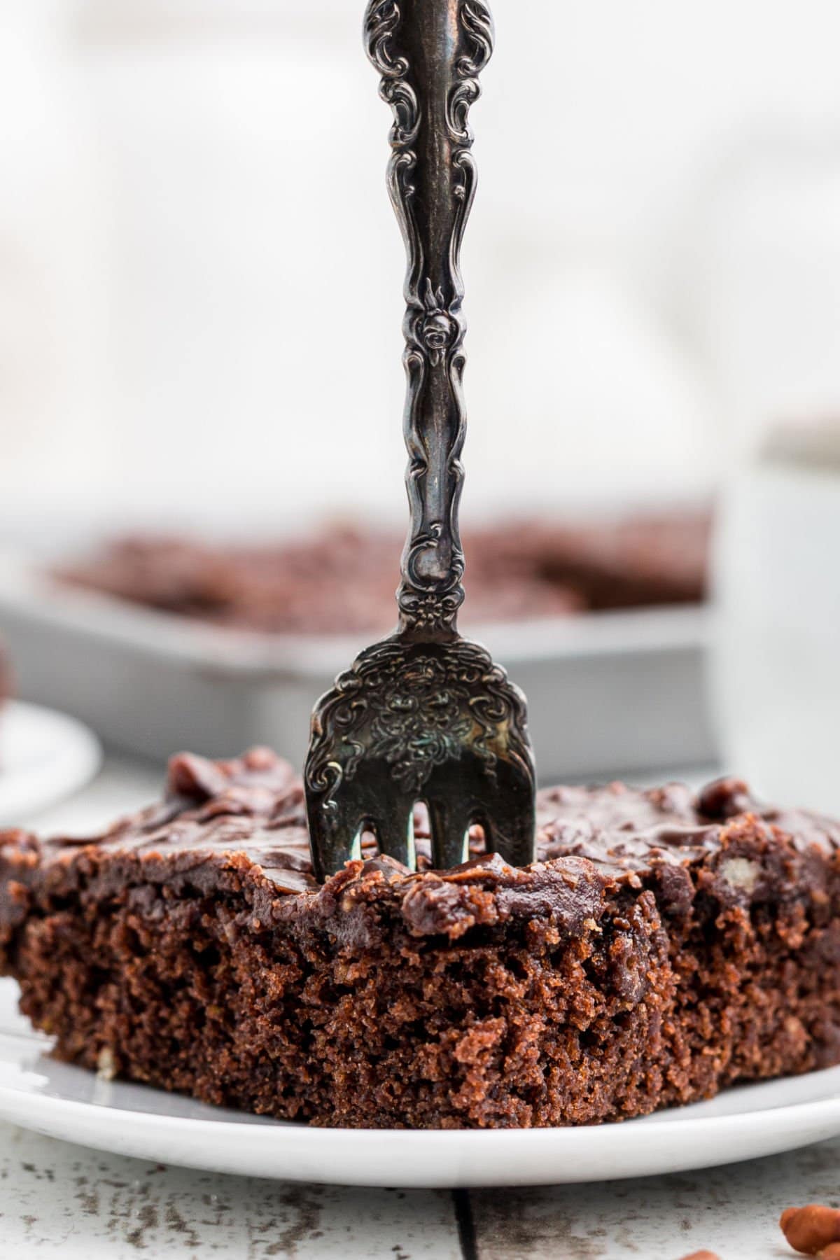 A fork in a slice of cake.