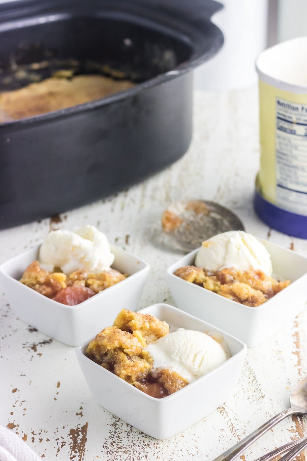 3 servings of dump cake in bowls with ice cream.