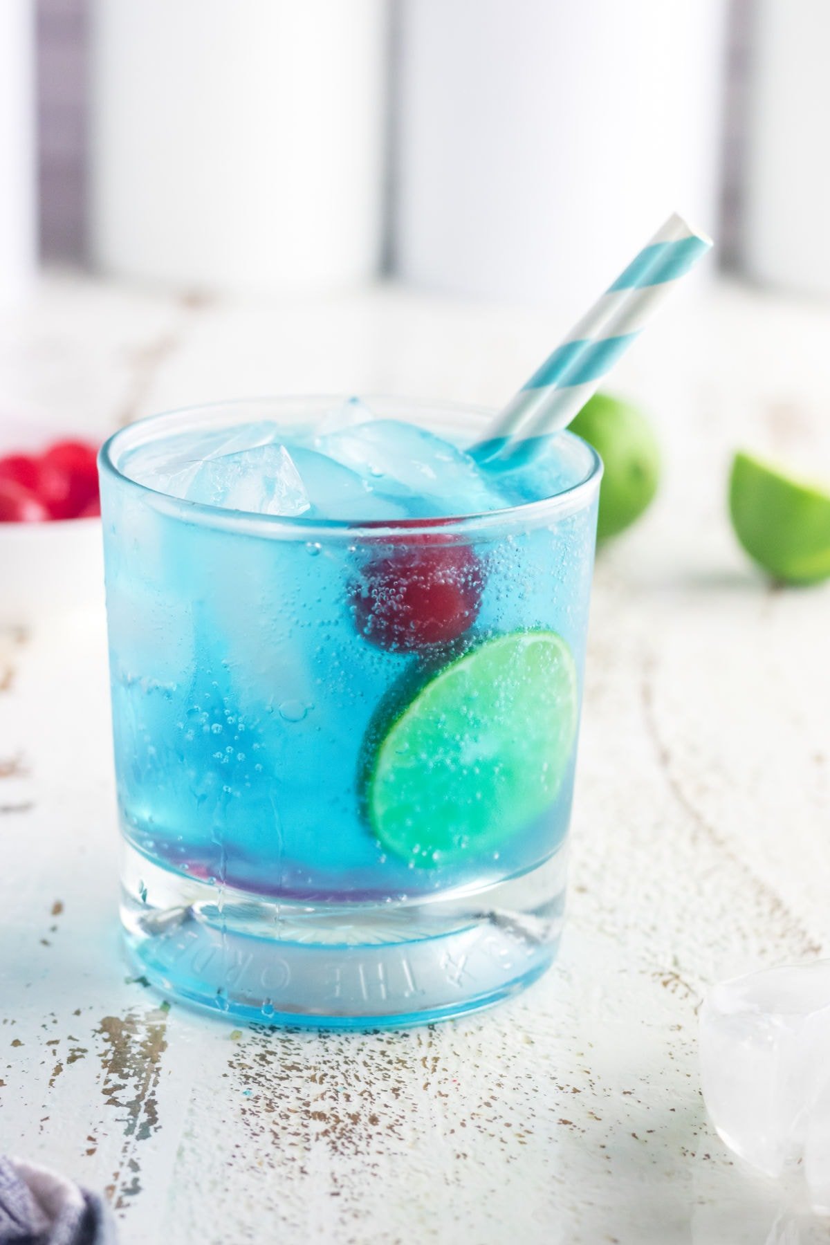 Side view of this cocktail with a blue and white straw.