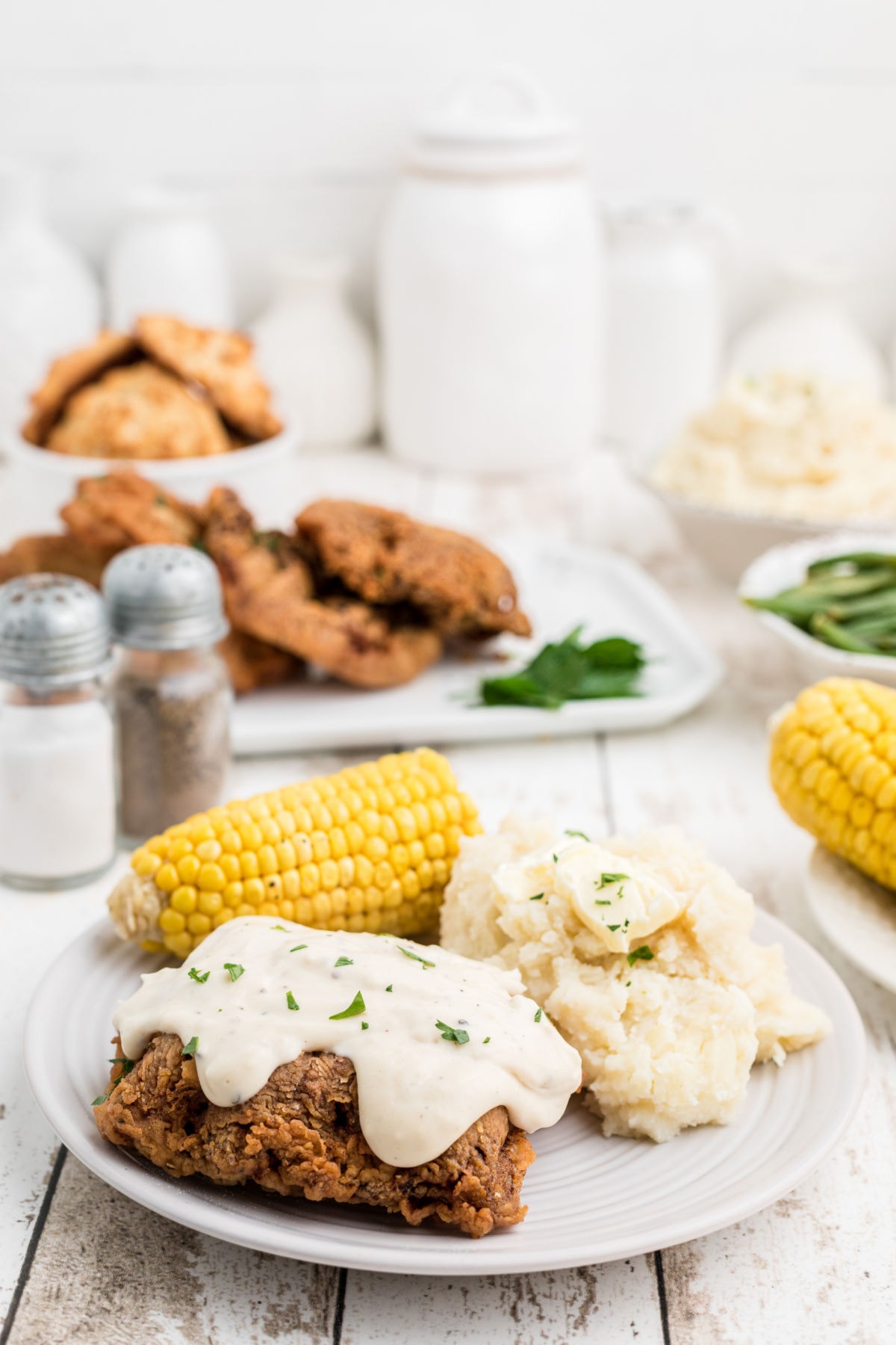 A dinner table with chicken fried steak on it.