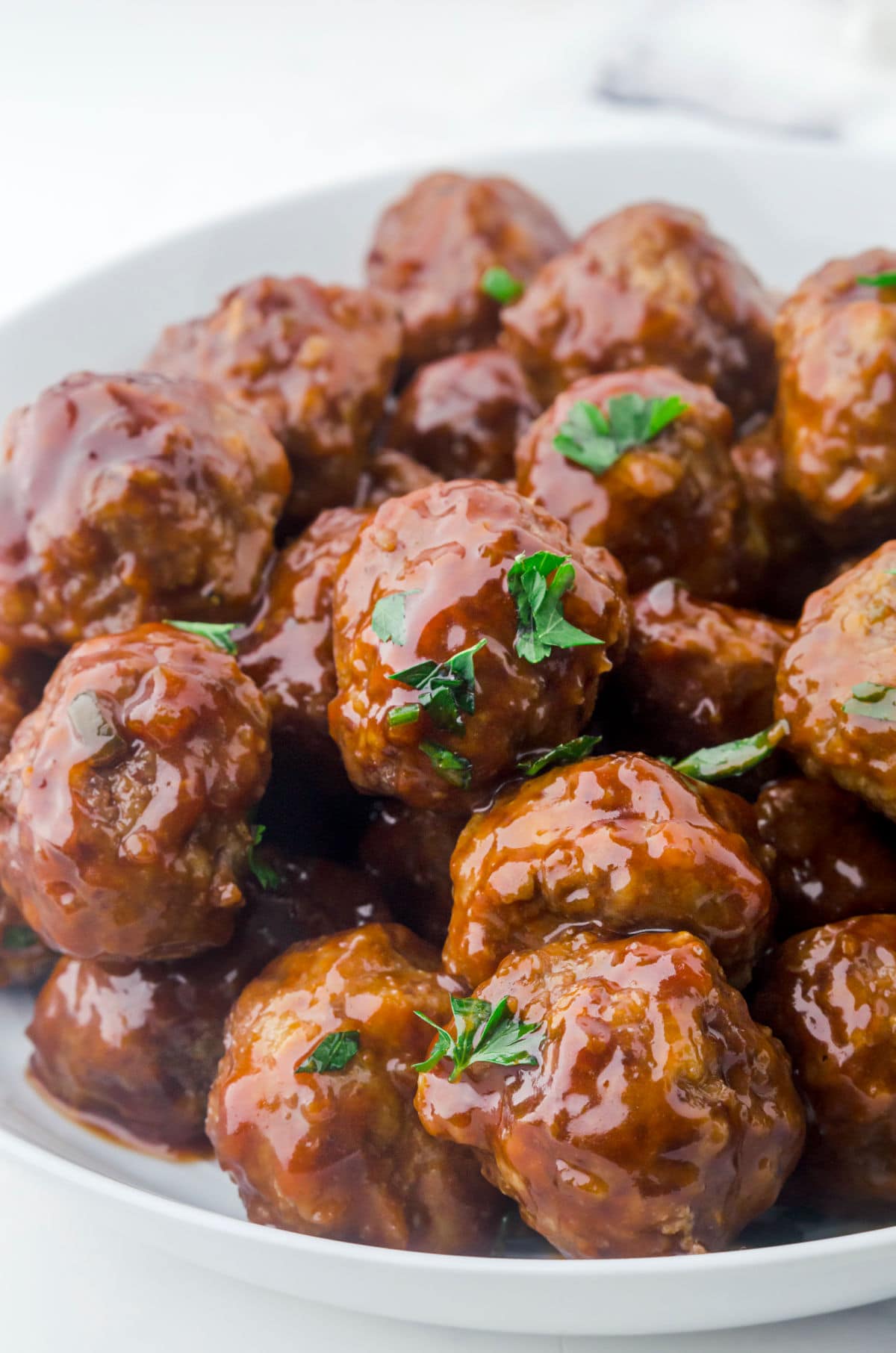Closeup view of glazed meatballs in a serving bowl.