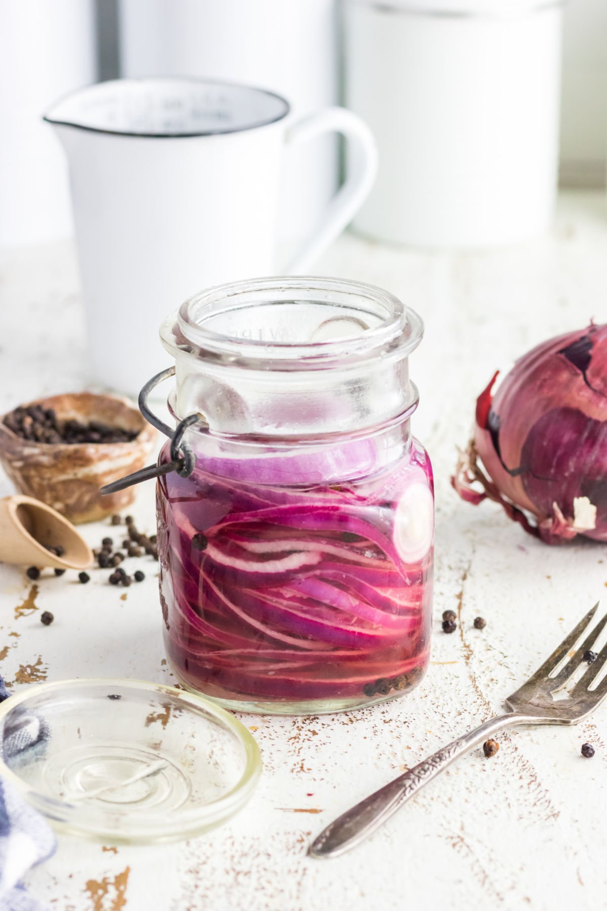 Jar of pickled onions on a table.