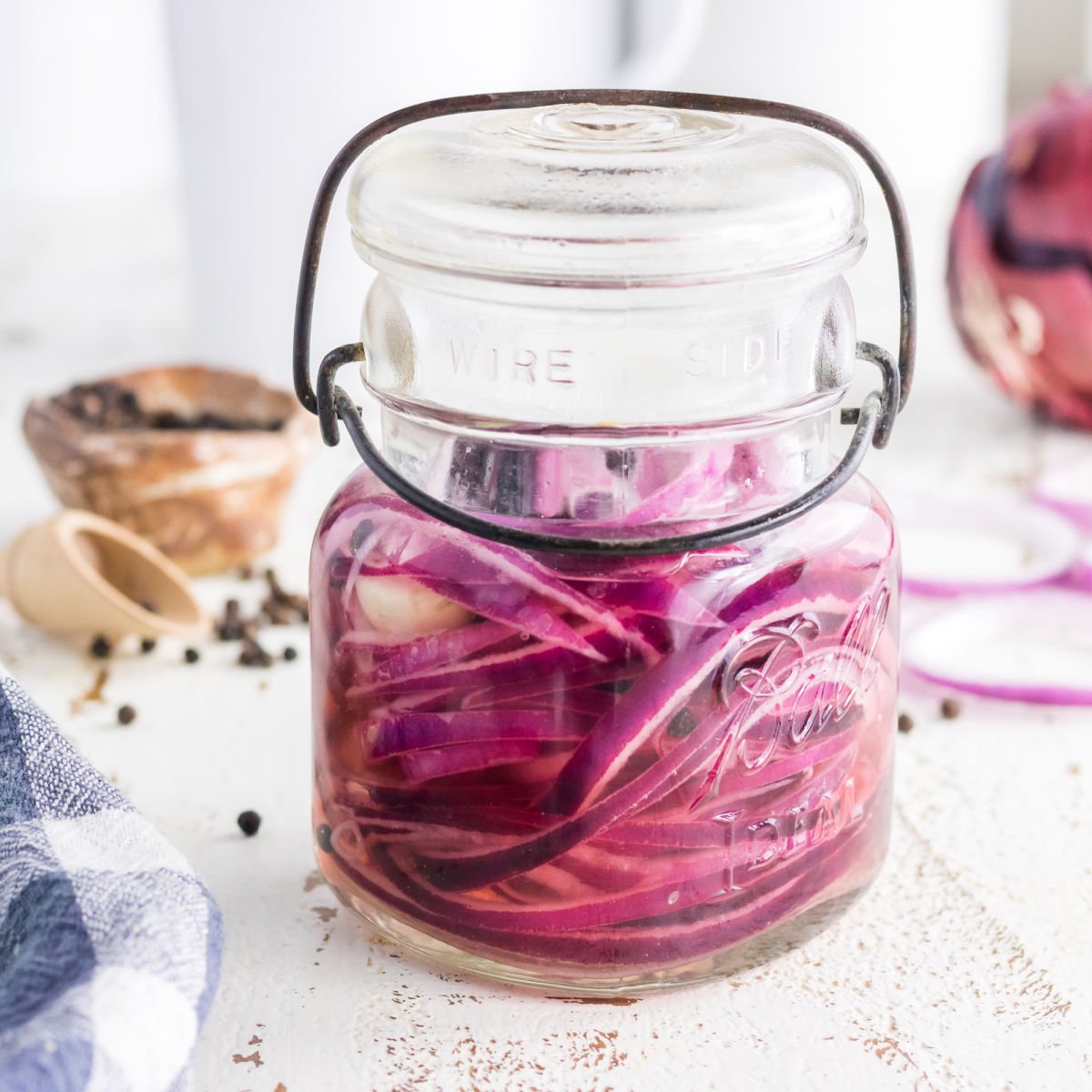 Closeup of pickled onions in a jar for featured image.