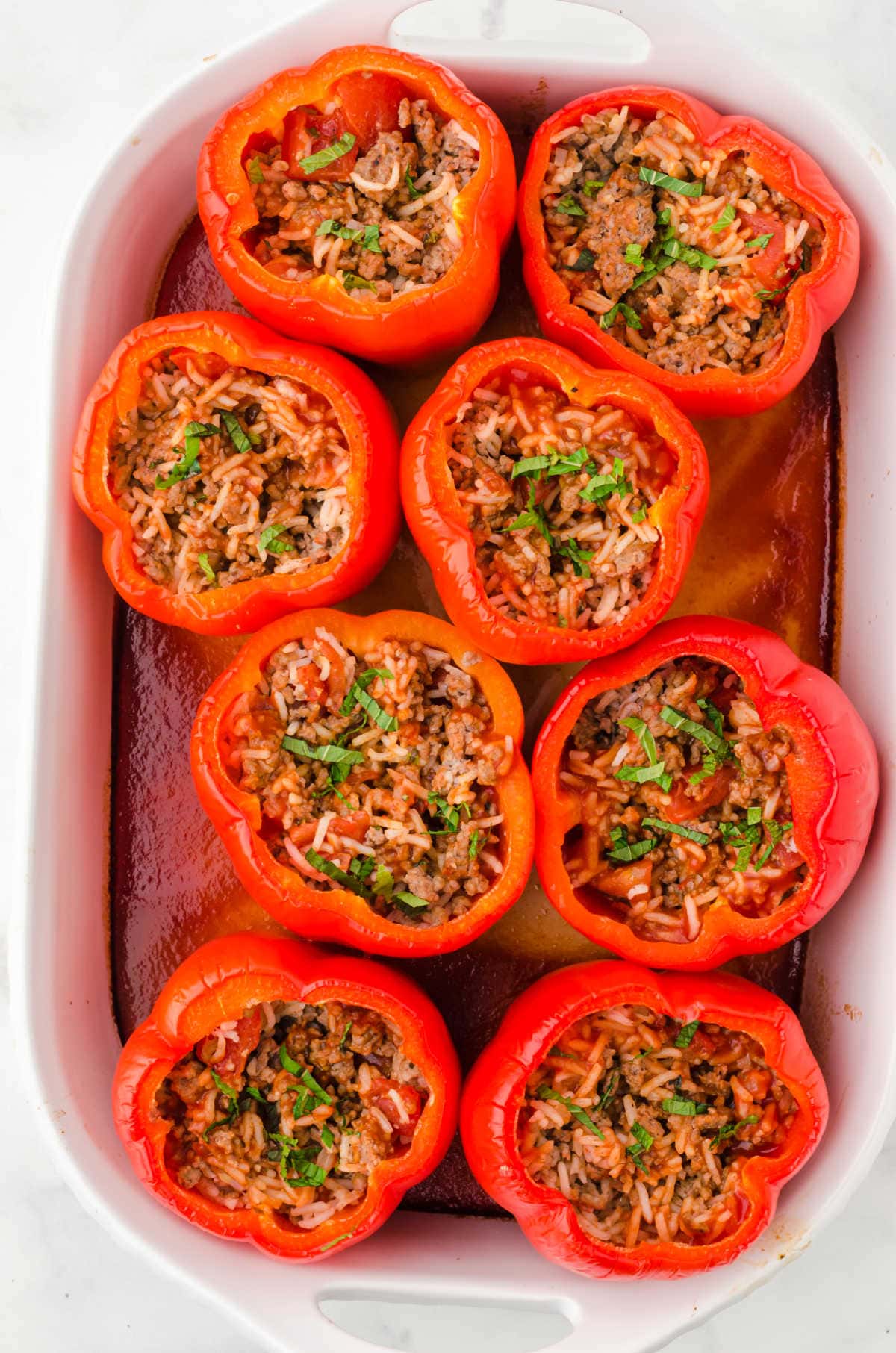 Overhead view of stuffed peppers in a casserole dish.