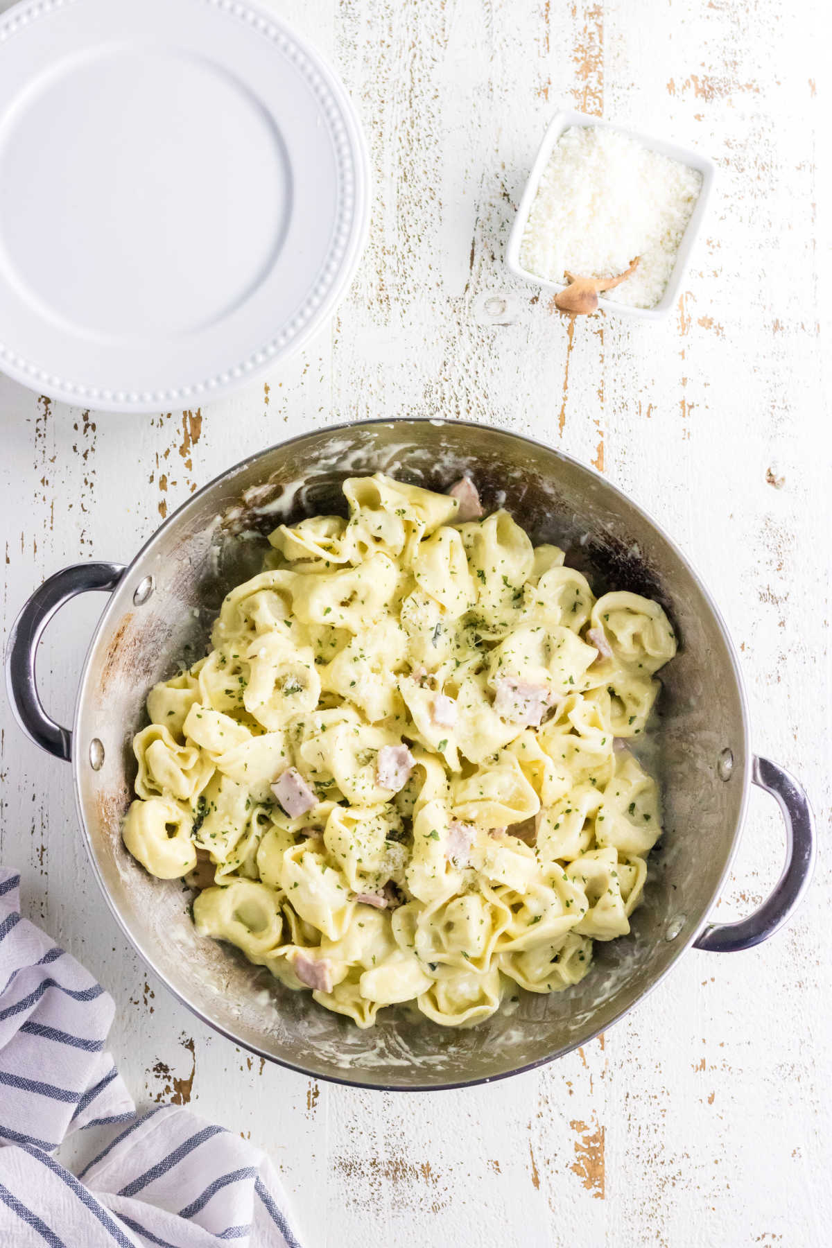 Tortellini with cream sauce in a pan.