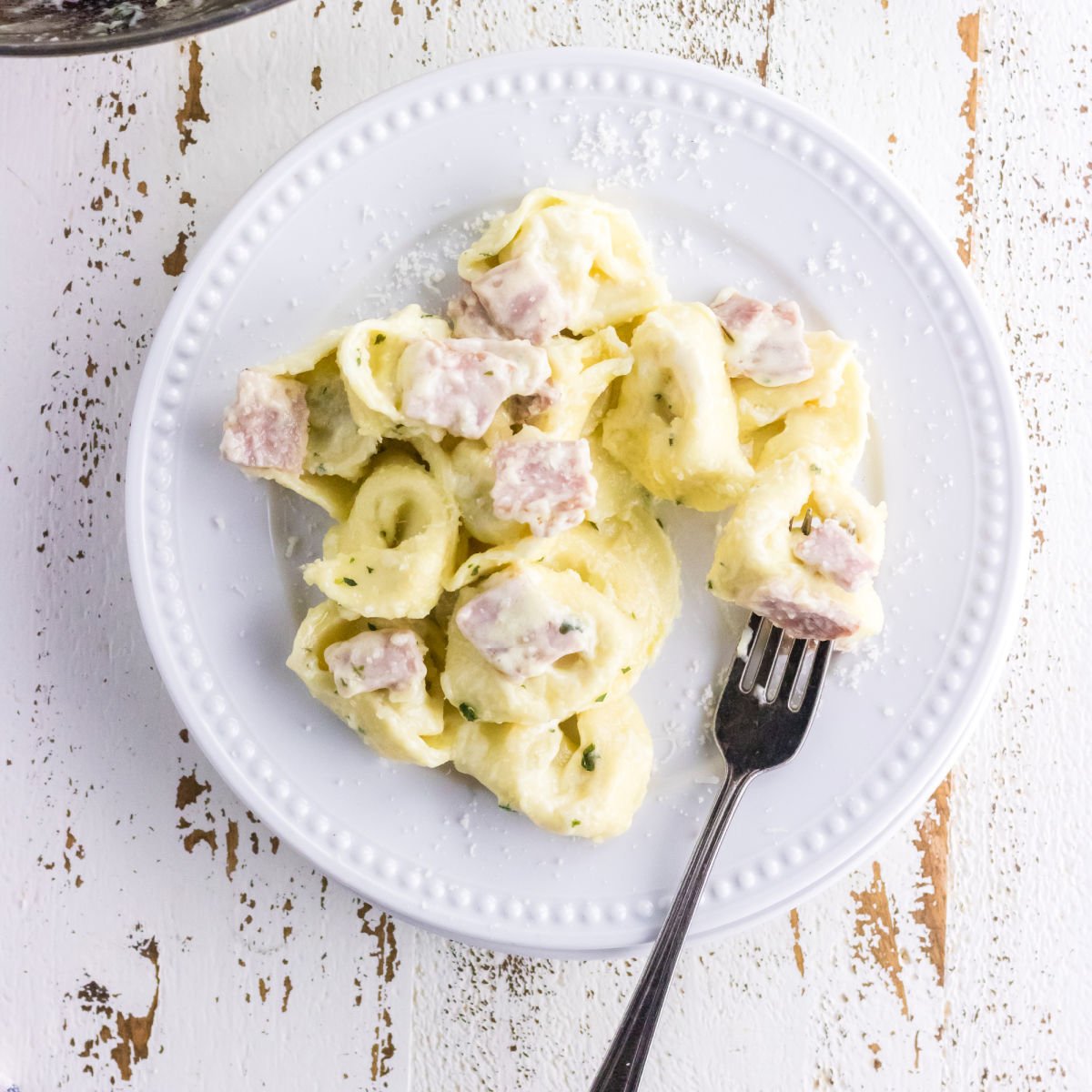 A closeup of tortellini alla panna on a plate.