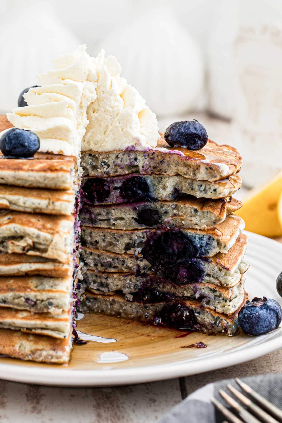 Close up of a stack of pancakes with a wedge cut out.