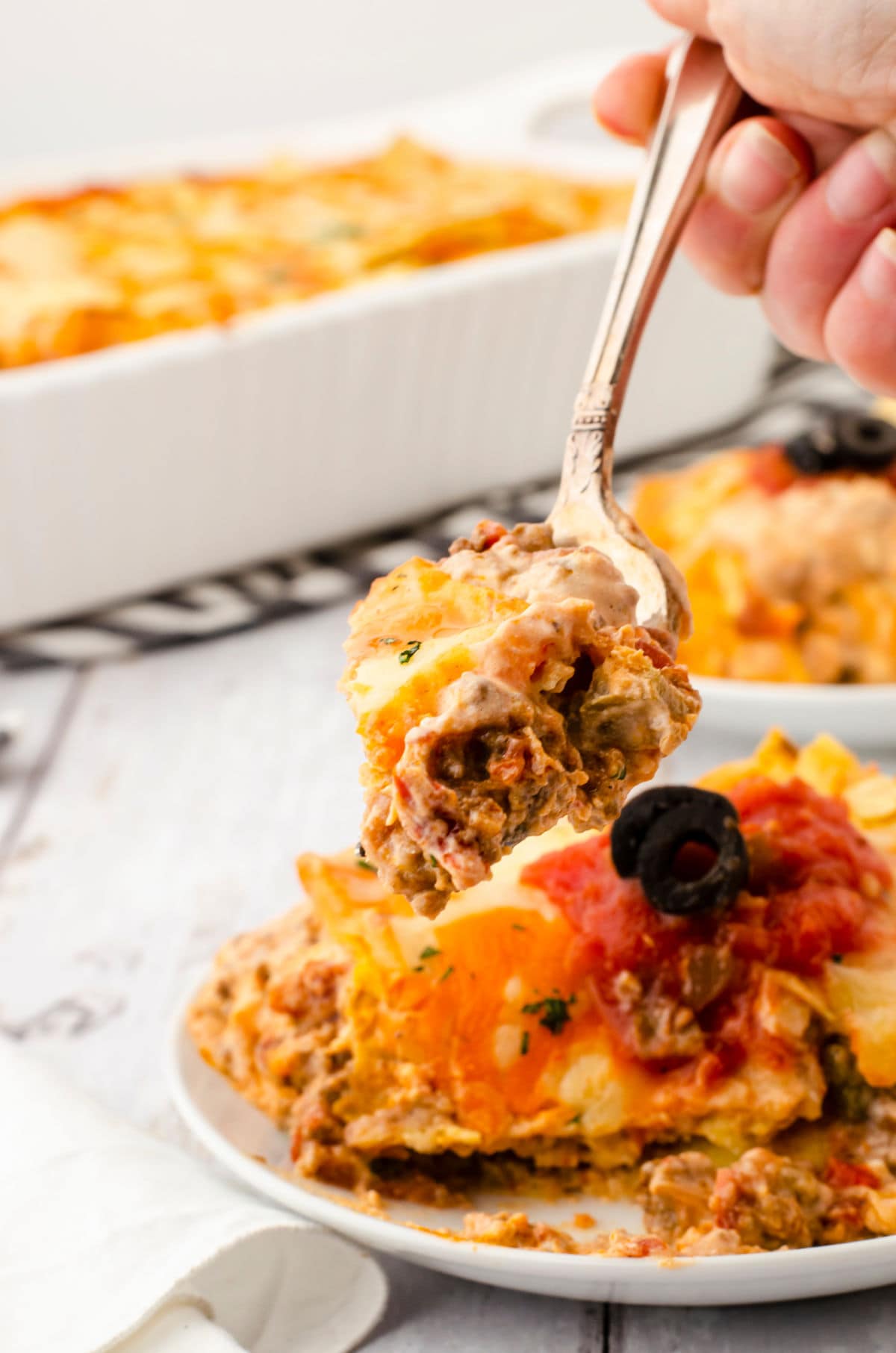 A forkful of casserole being lifted from the plate.