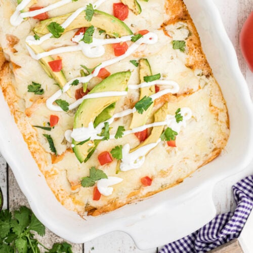 Closeup of finished chicken enchiladas in a baking dish.