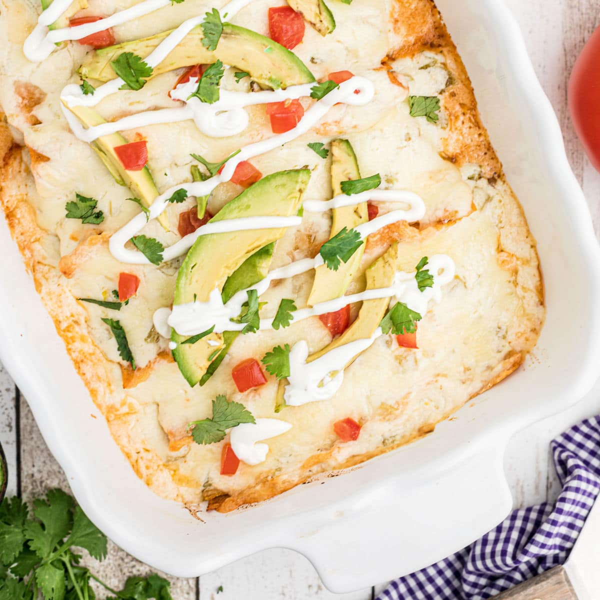 Closeup of finished chicken enchiladas in a baking dish.