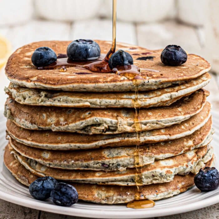 A stack of pancakes with blueberries on top.