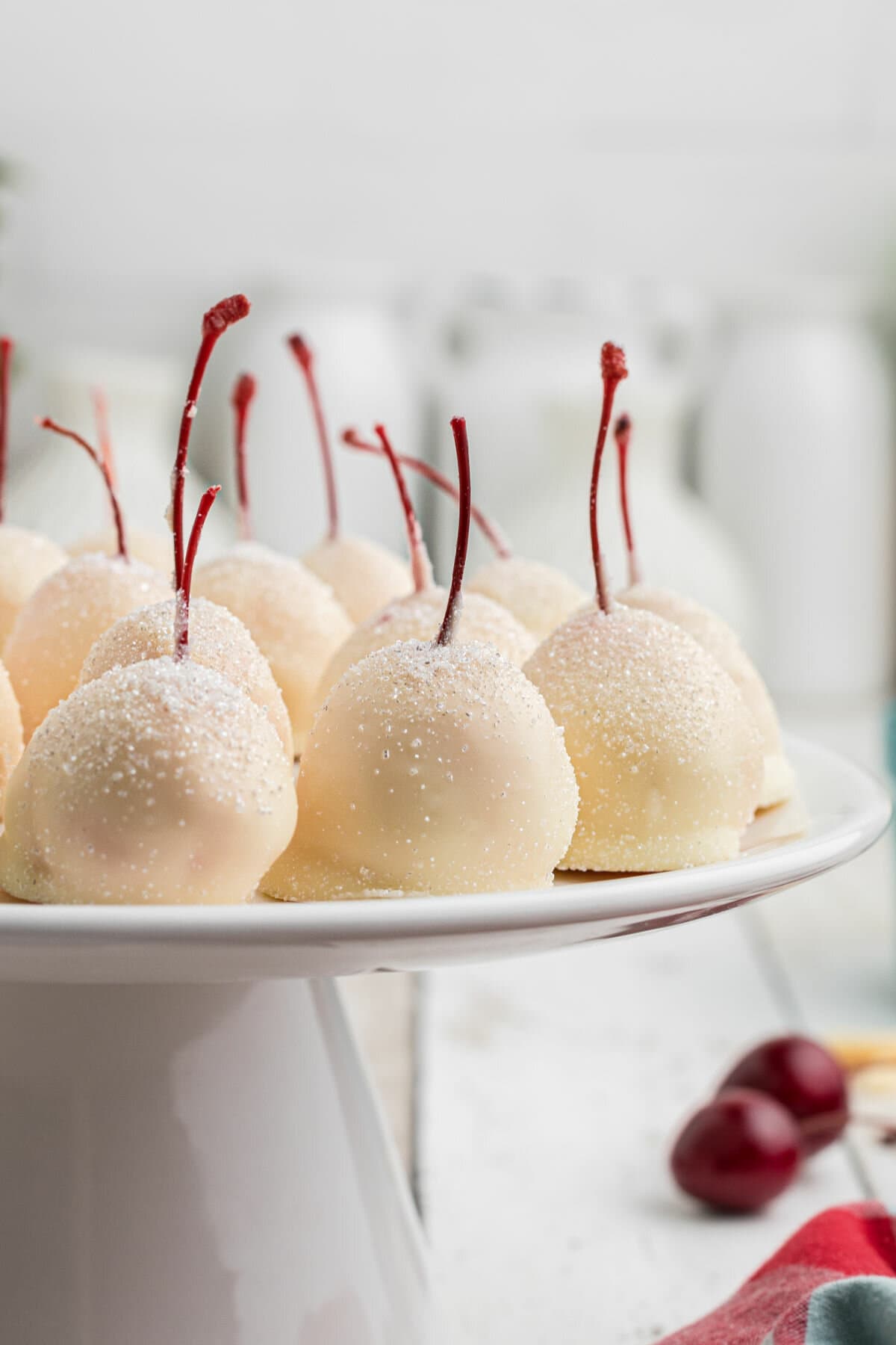 Decorated chocolate covered cherries on a plate.