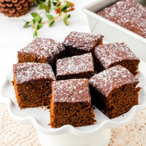 Closeup of squares of gingerbread on a cake plate.