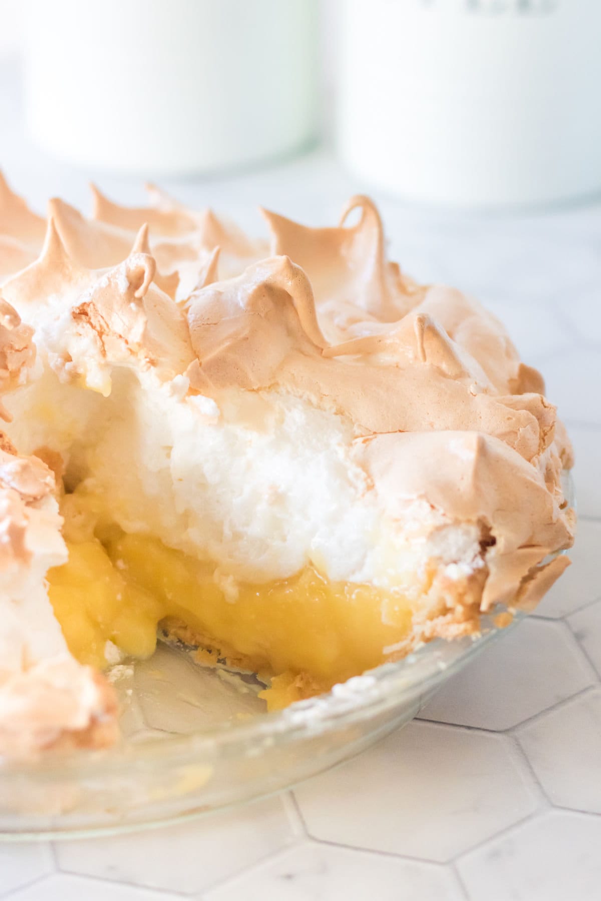 Lemon meringue pie with a slice taken out of it.