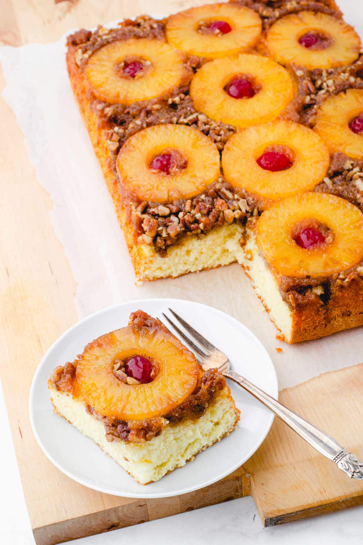 A serving of pineapple upside down cake on a white plate.