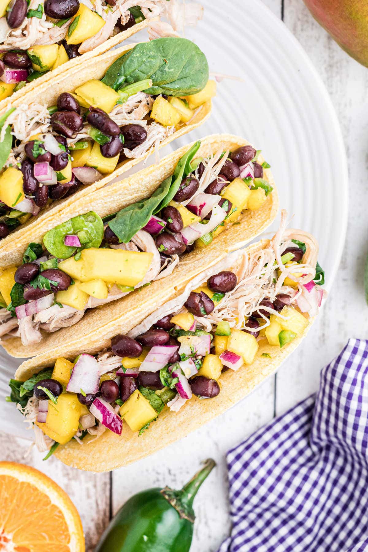 Corn tortillas filled with pulled pork and mango salsa.