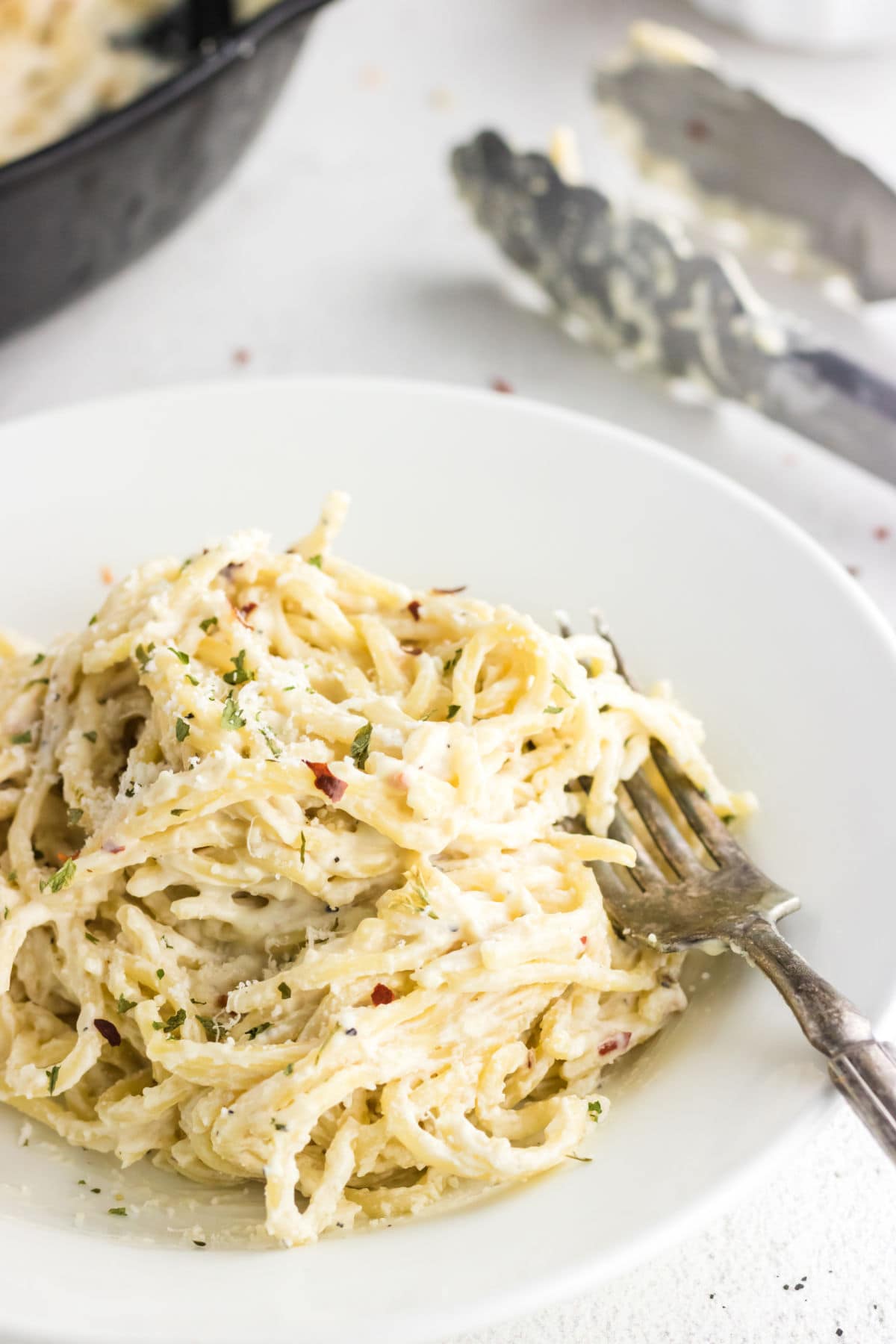 A closeup of a serving of pasta with cream cheese sauce.