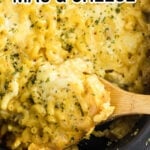 A serving of mac & cheese being spooned out of the slow cooker with text overlay for Pinterest.