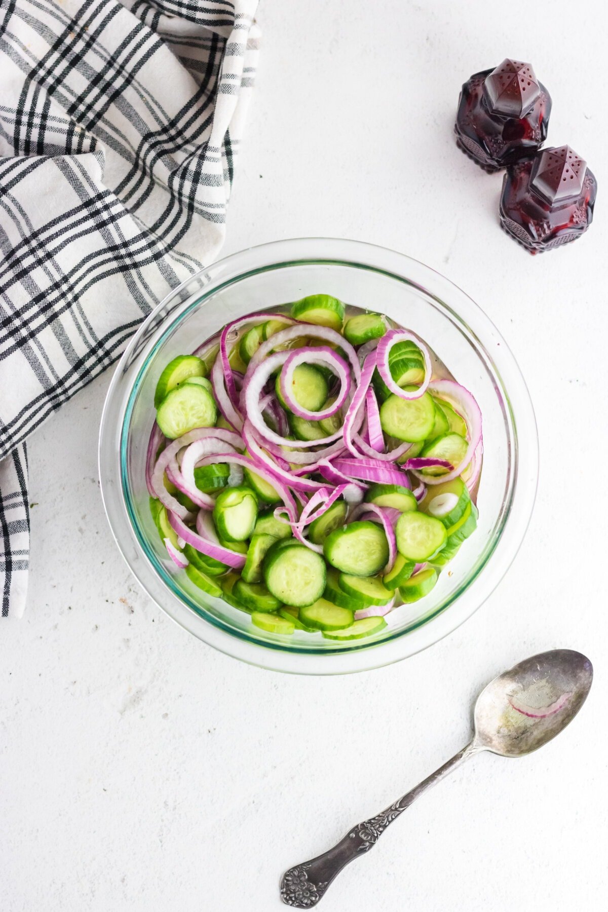 Overhead view of finished cucumber salad in a glass bowl.