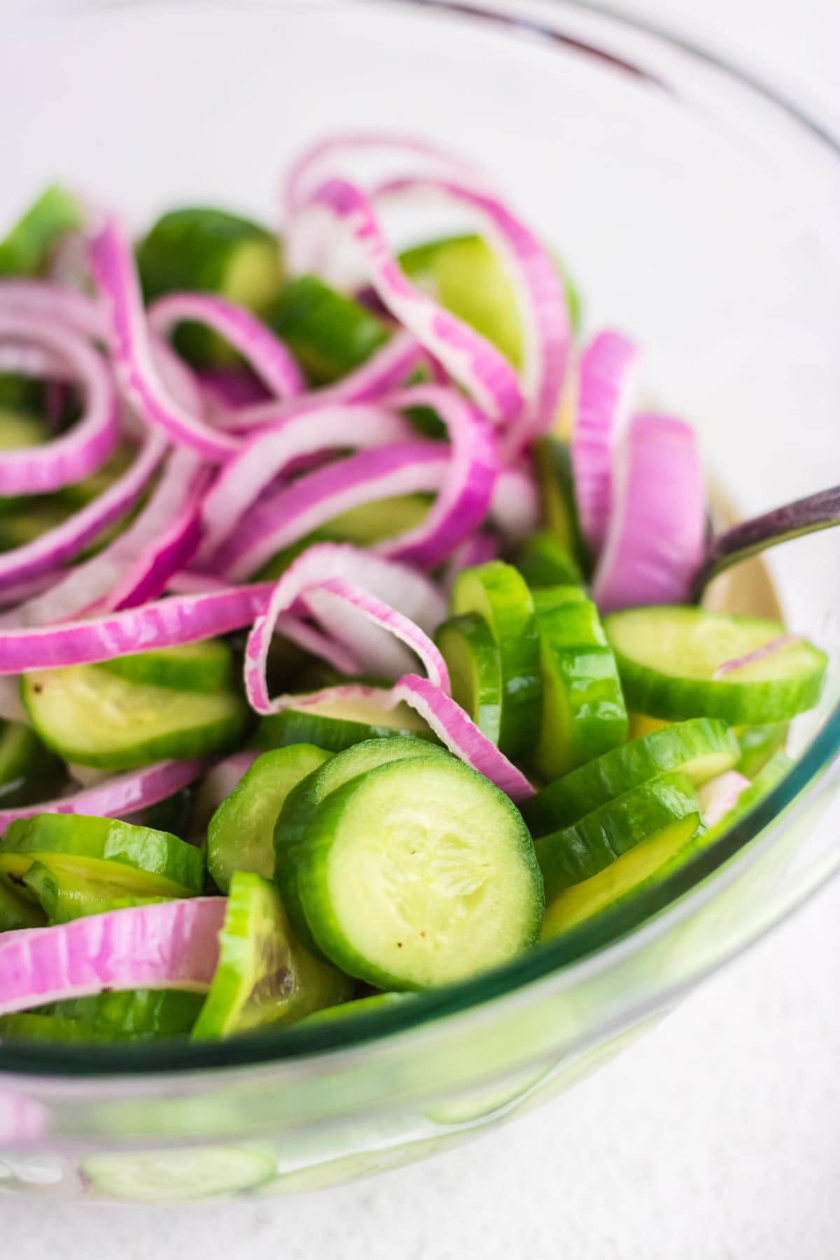 Closeup of the cucumbers and purple onions in a bowl.
