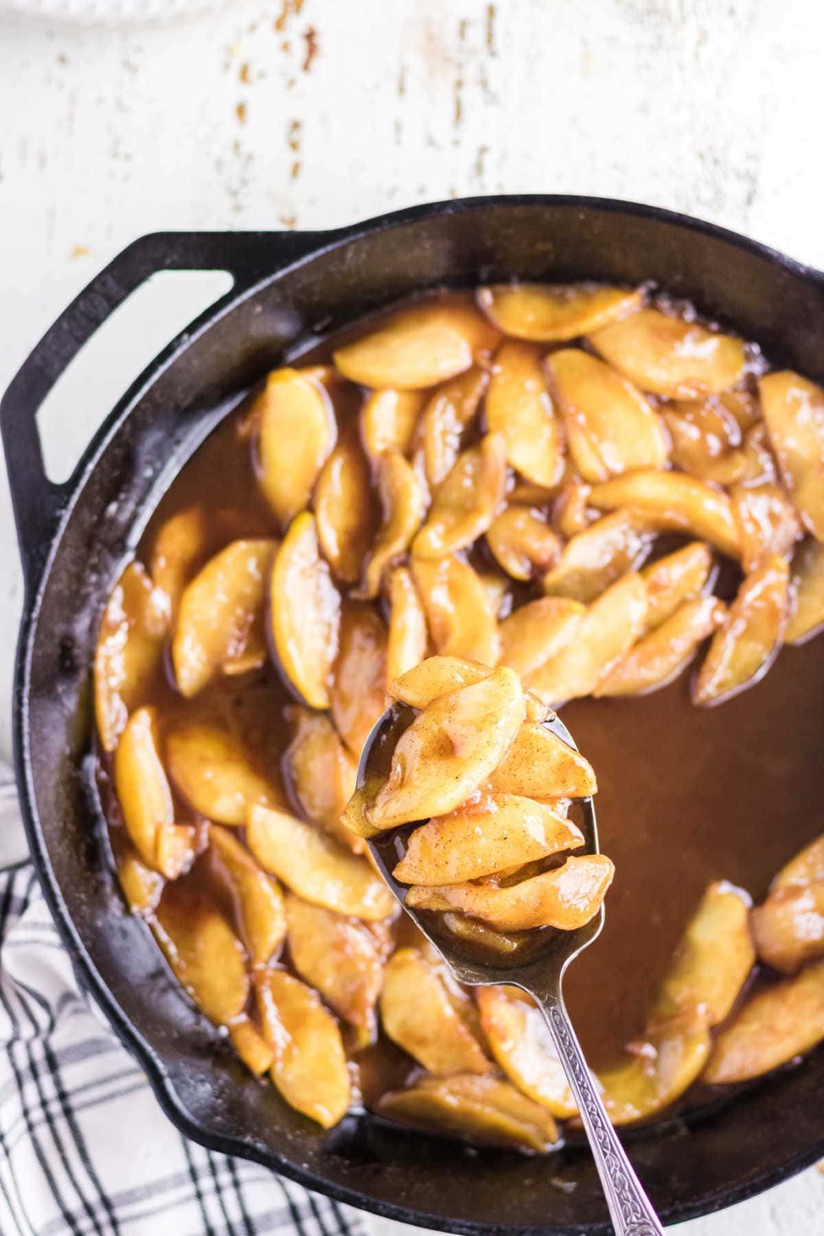 Closeup of a serving of apples being removed from the pan.