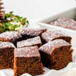 Gingerbread squares on a cake plate with a text overlay for Pinterest.