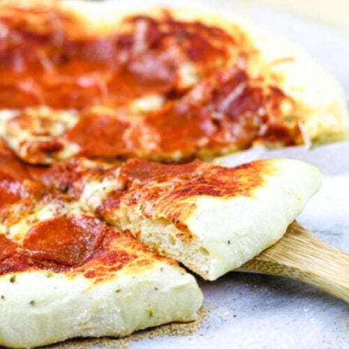 A closeup of a slice being removed from a pizza.