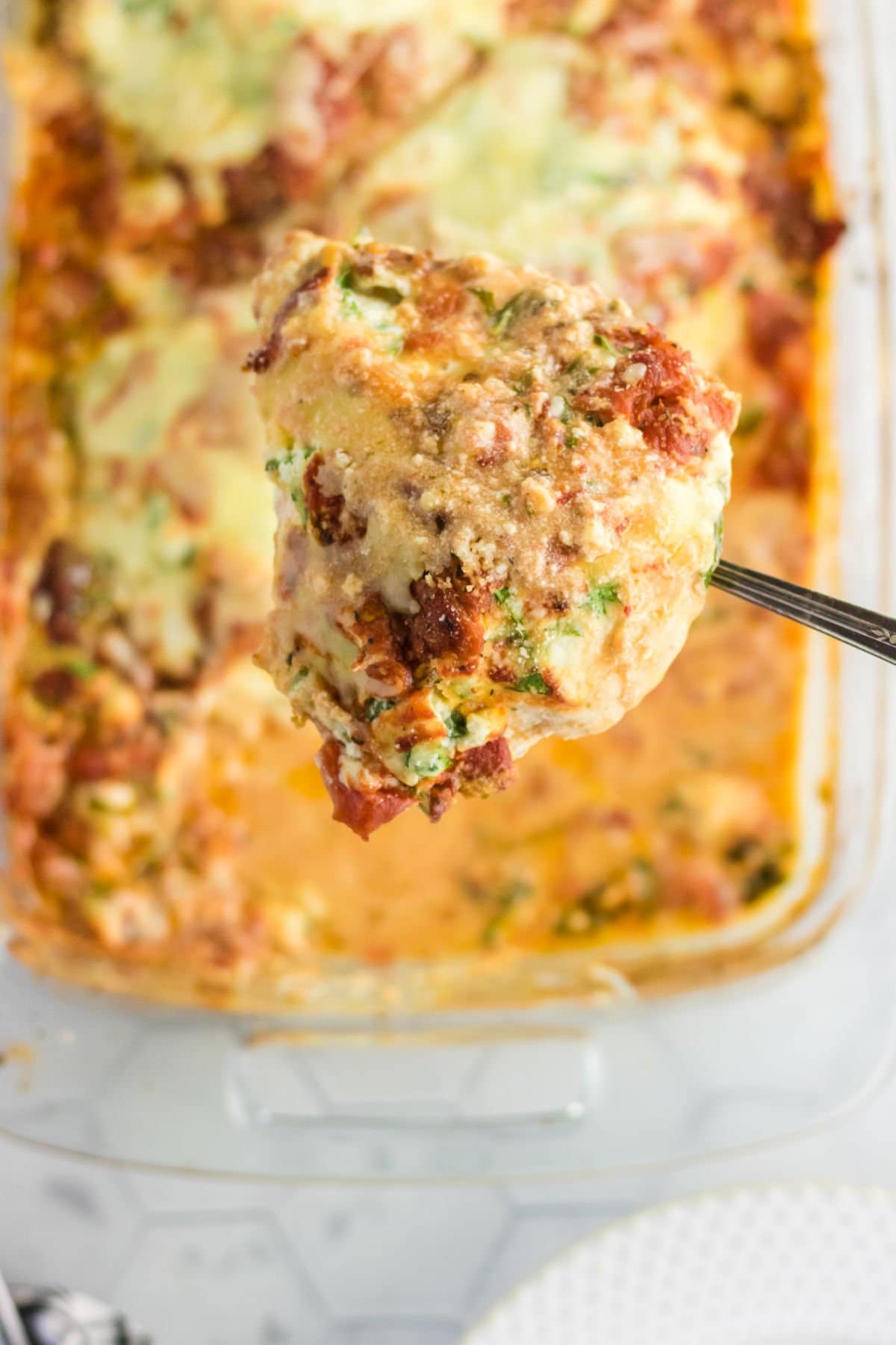 A serving of ricotta stuffed chicken being lifted from the pan.