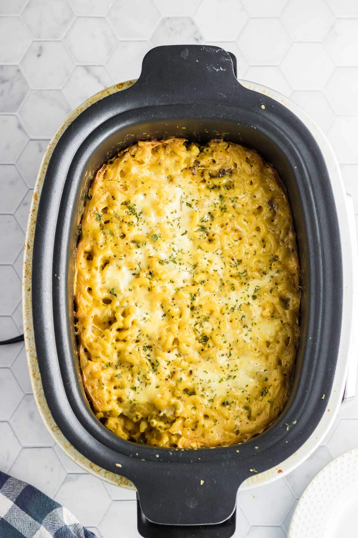 A crockpot with macaroni and cheese in it.