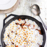 Overhead view of candied yams in a skillet with text overlay for Pinterest.