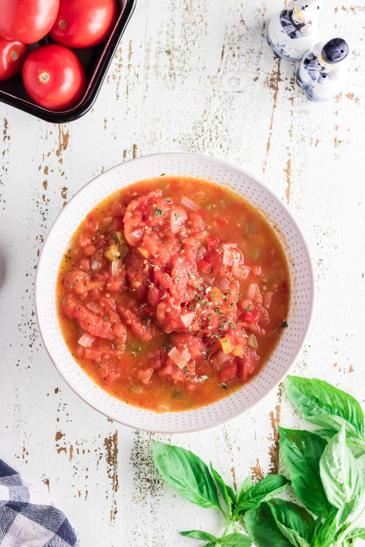 A serving bowl filled with stewed tomatoes.