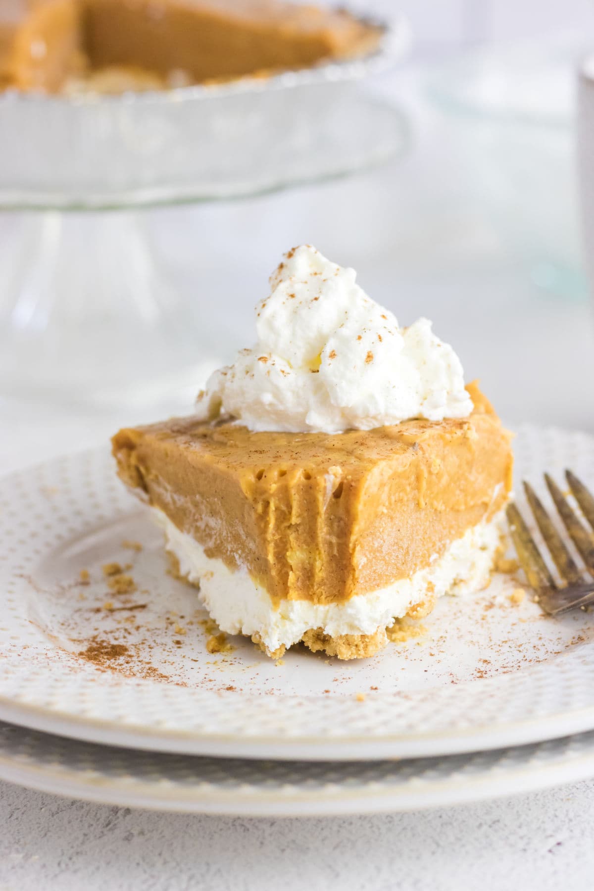 Double layer pumpkin pie slice with a bite removed.