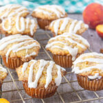 Peach muffins with a glaze drizzled over the top.
