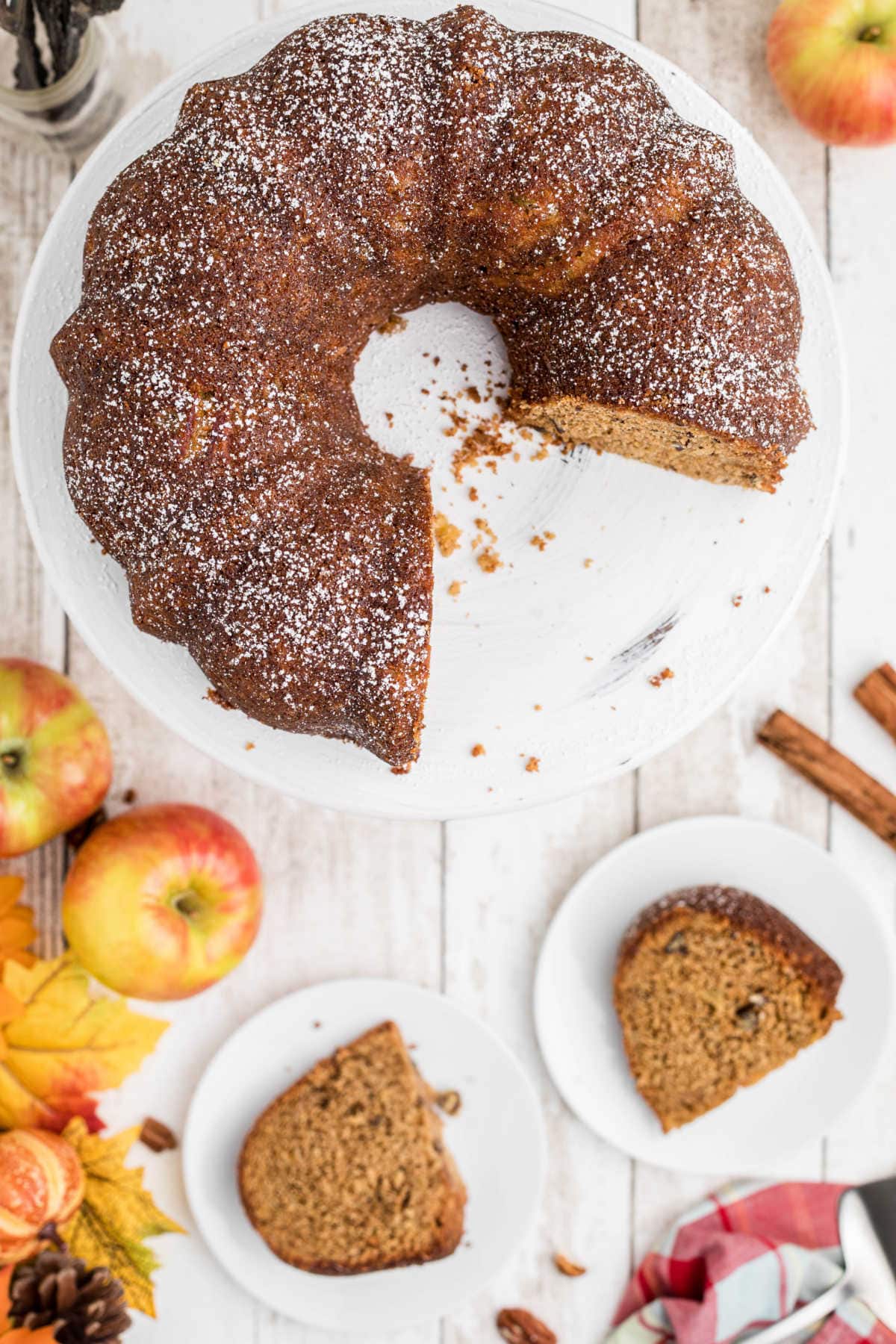 Overhead view of bundt cake with two servings on plates next to it.