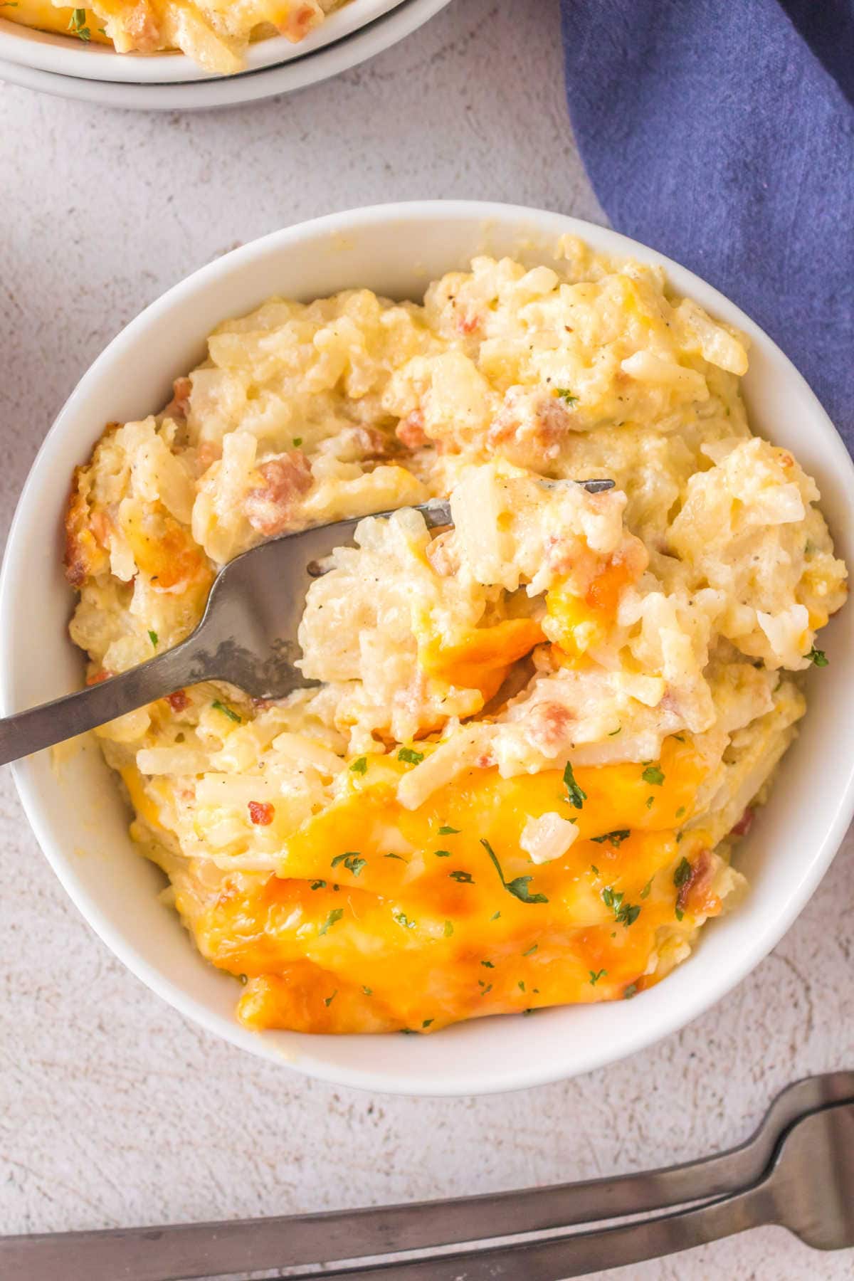 A bowl of hashbrown casserole ready to eat.
