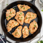 Overhead view of an iron skillet with finished chicken in it.