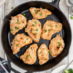 Overhead view of an iron skillet with finished chicken in it.