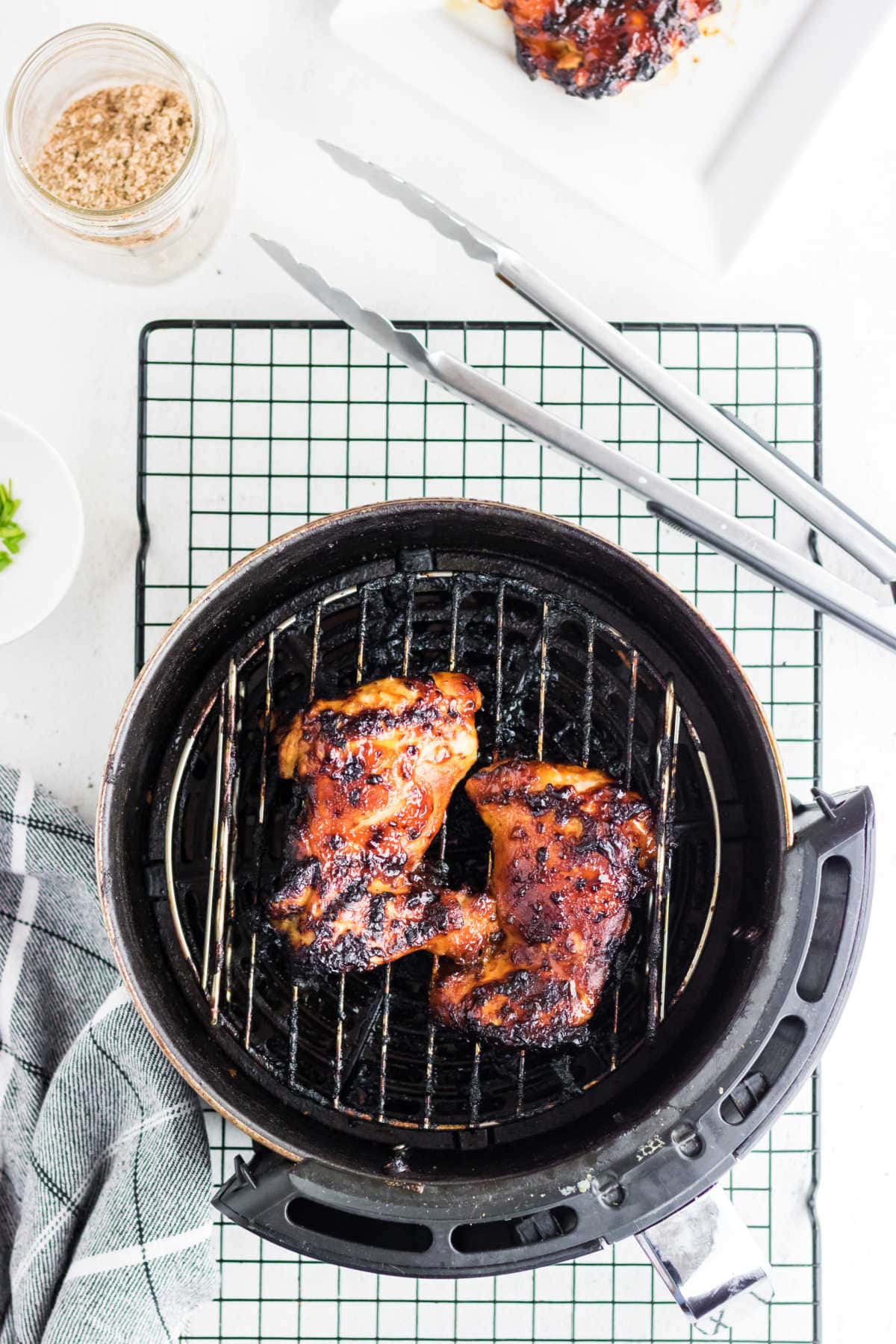 Finished chicken being removed from the air fryer.