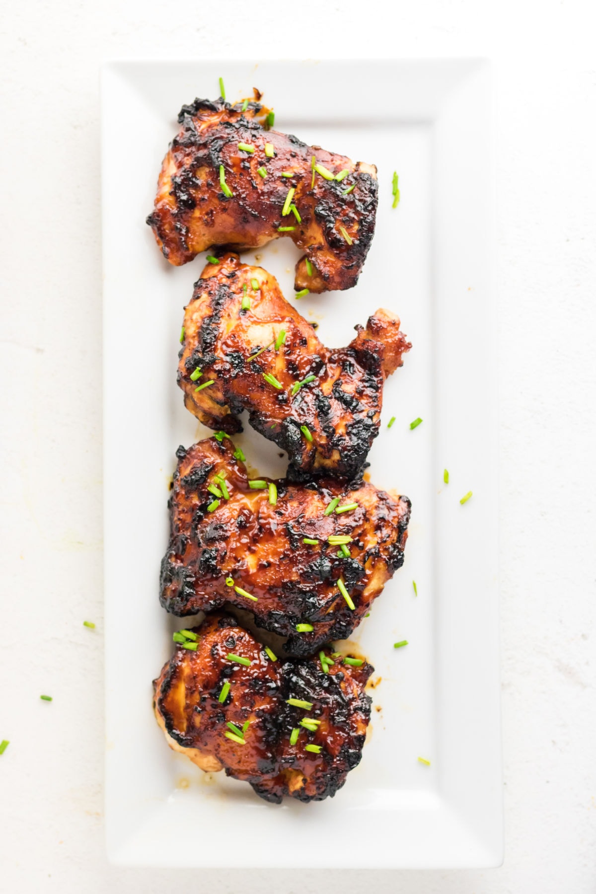 Finished chicken thighs on a plate.