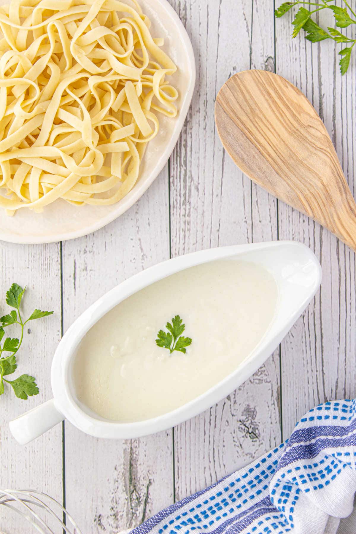 Overhead view of cream sauce in a gravy boat.