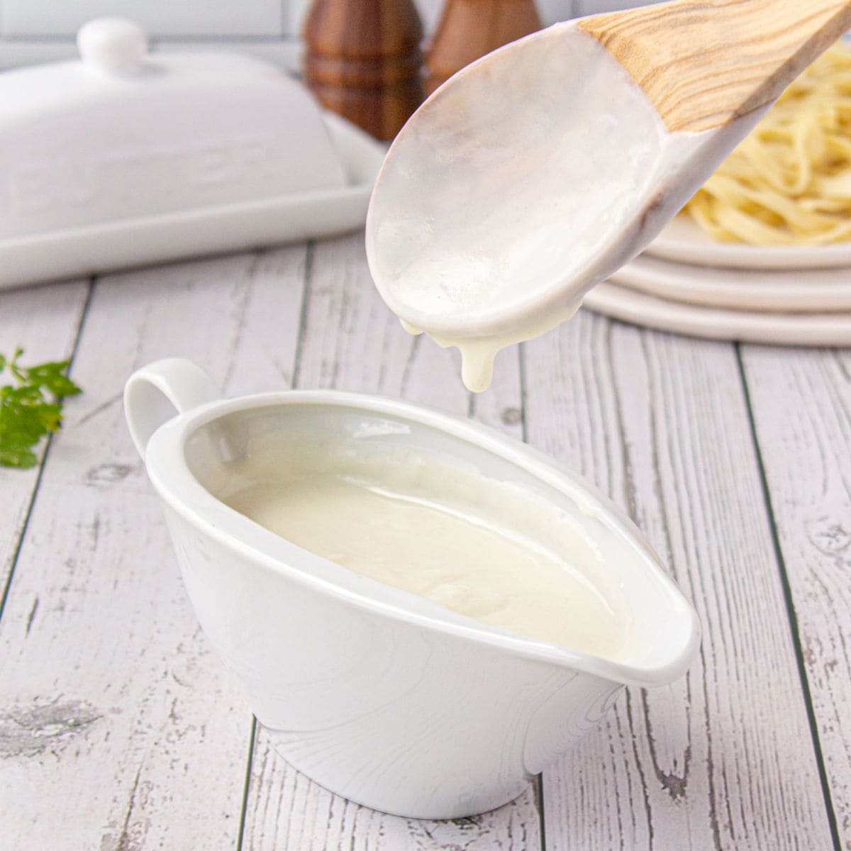 Cream sauce being added to a gravy boat.